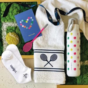 Play All Day Kit with socks, a towel, pink racquet pen, and water bottle
